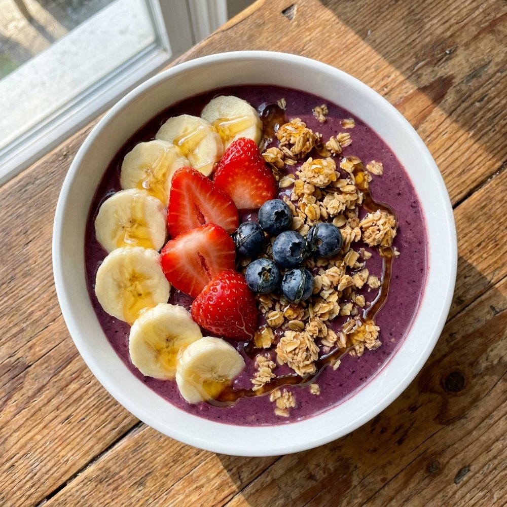 A fresh açaí bowl topped with banana, berries and granola